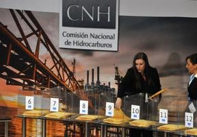 7 urnes transparentes avec à l’intérieur de chacune les enveloppes comprenant les propositions des différentes sociétés internationales.