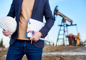 An inspector in oil field holding folder for notes