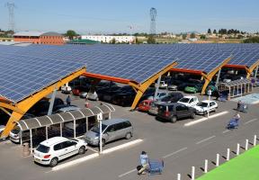 A photo of a supermarket in the south of France. Its parking lot is sheltered by canopies with solar PV panels.