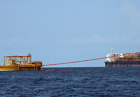 Oil tanker loading operation near a giant offshore barge 
