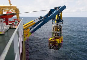 Deep offshore production requires the use of sophisticated robotic equipment. Here we see a remotely operated vehicle (ROV) being launched.