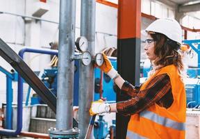 Ouvrière industrielle régulant la pression d'une vanne de pression d'air comprimé