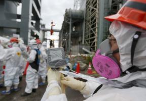 Personnel dans une zone nucléaire portant un dosimètre pour mesurer la quantité de rayonnements