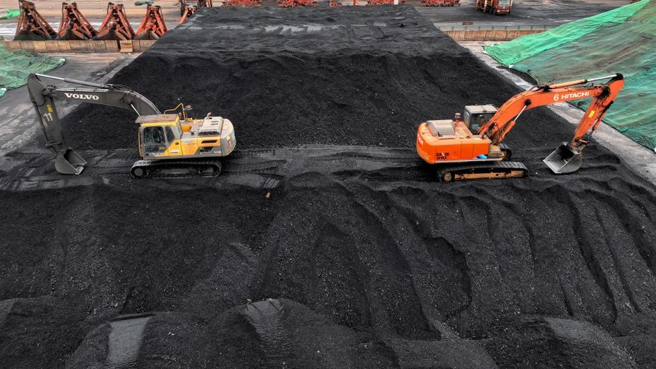 Une photo aérienne montrant les grandes machines qui empilent et stockent le charbon au terminal charbonnier du port de Lianyungang, Chine.