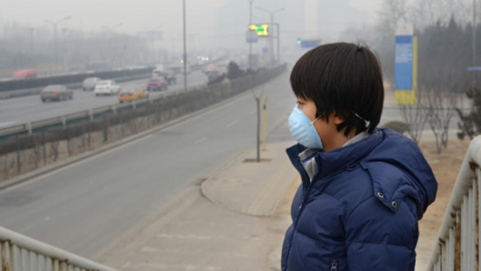 Jeune chinois portant un masque à cause de la pollution de l’air à Pékin.
