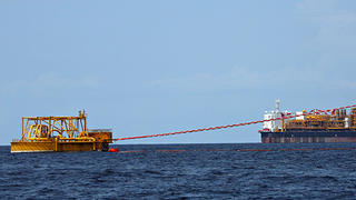 Opération de chargement d'un tanker près d'une barge off-shore géante au large de l'Angola