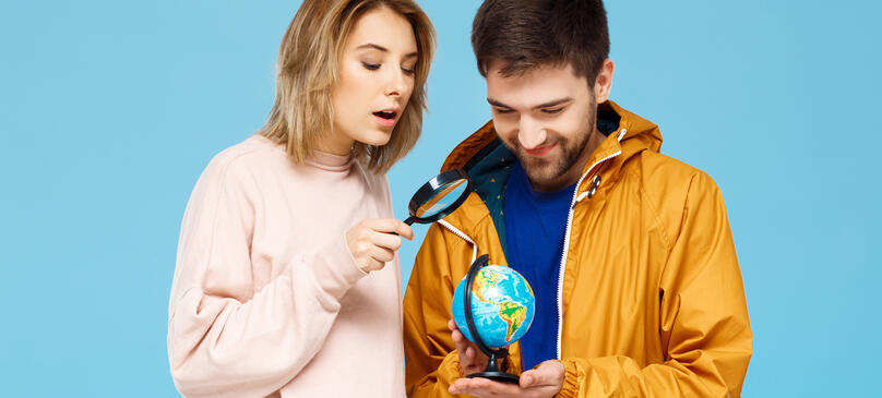 Amis regardant une mappemonde à la loupe